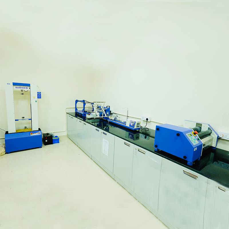 Textile quality control laboratory of NM Exports with various blue and white testing instruments, including an AutoStretch machine
